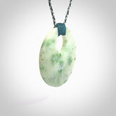 Hand carved by Rueben Tipene, this lovely Jadeite pendant is hand made and an absolute delight. One pendant only, postage is included in the price. One White Siberian Jade pendant. White Siberian Jadeite oval disc pendant. Perfect gift for someone special. The shape of the pendant is a disc form.